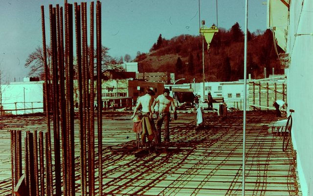 Old image of two men working on a construction site.