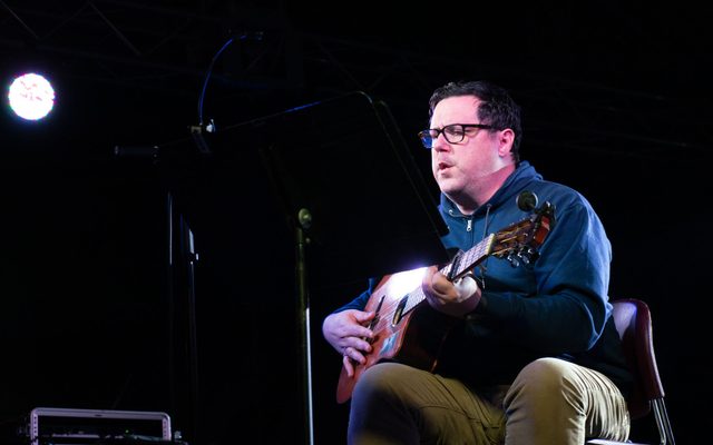Image of musician performing on stage with guitar