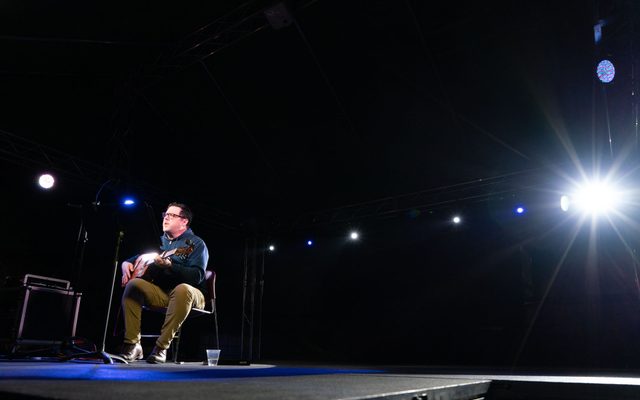 Image of musician performing on stage with guitar