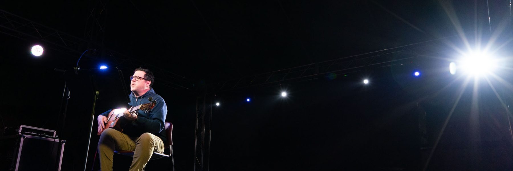 Image of musician performing on stage with guitar