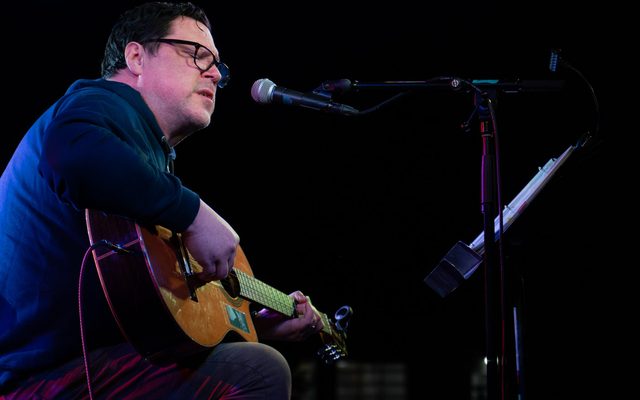Image of musician performing on stage with guitar