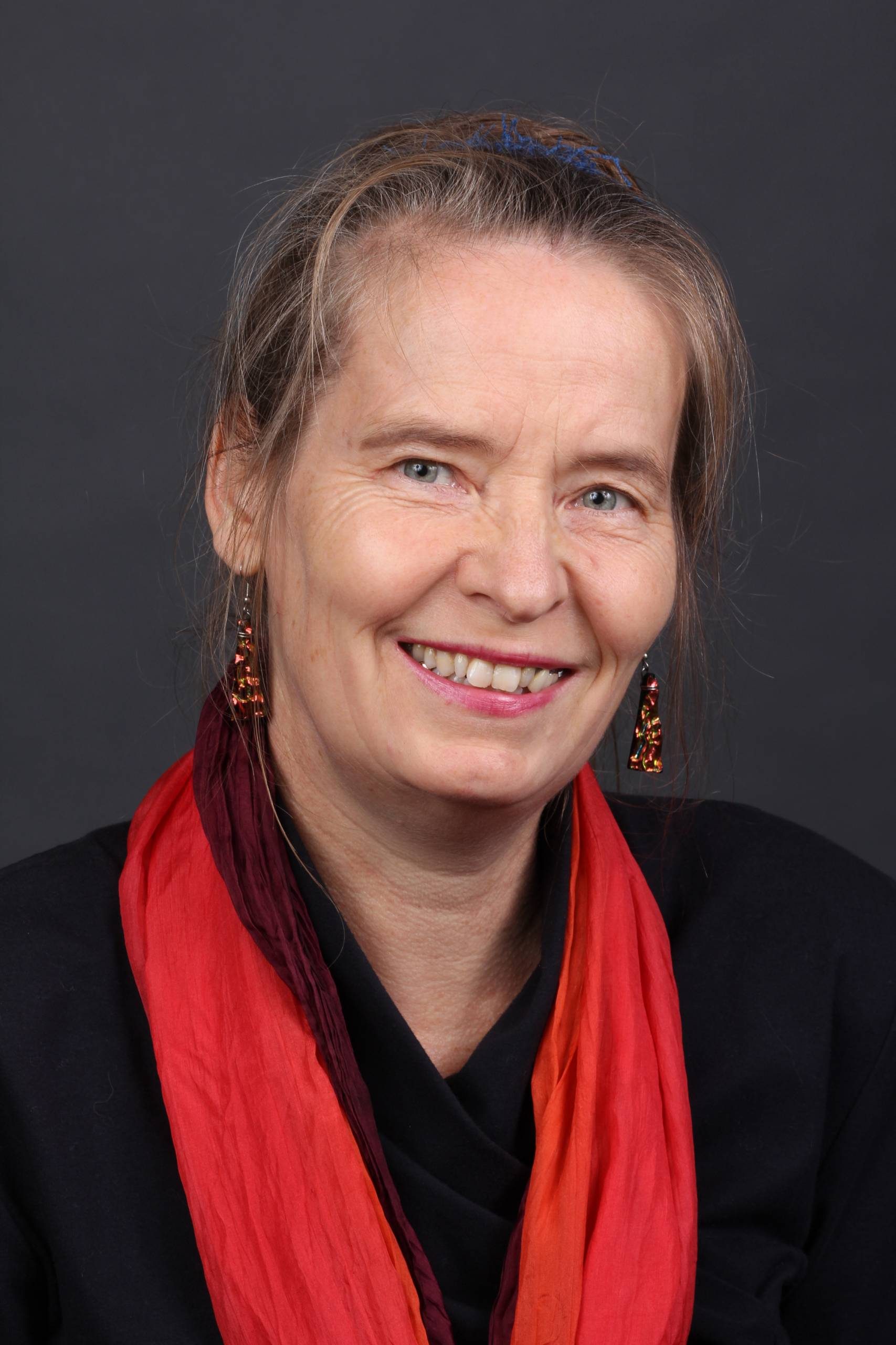 Headshot of Dorothee Ostmeier, woman wearing a black shirt and red scarf