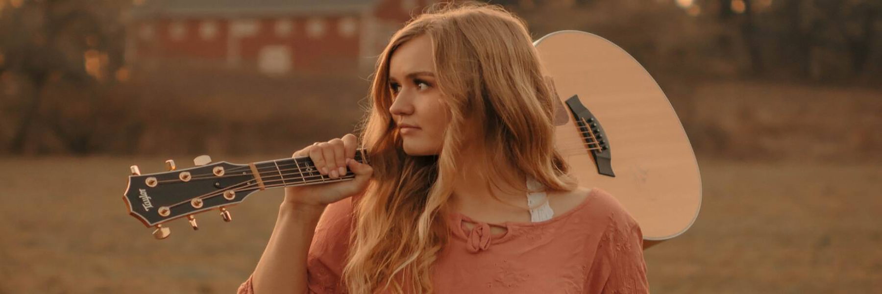 Image of McKayla Marie outside holding a guitar