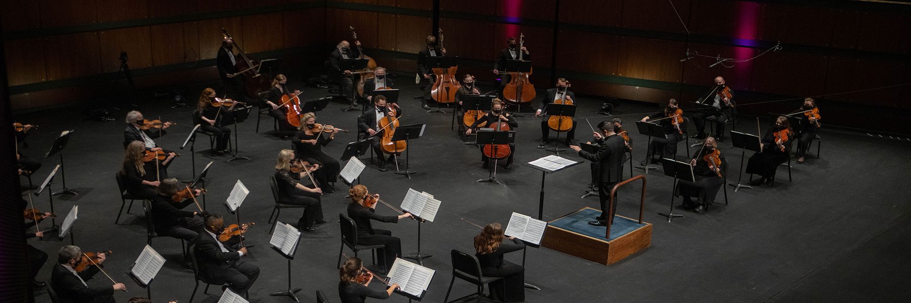 Image of conductor leading an orchestra on stage
