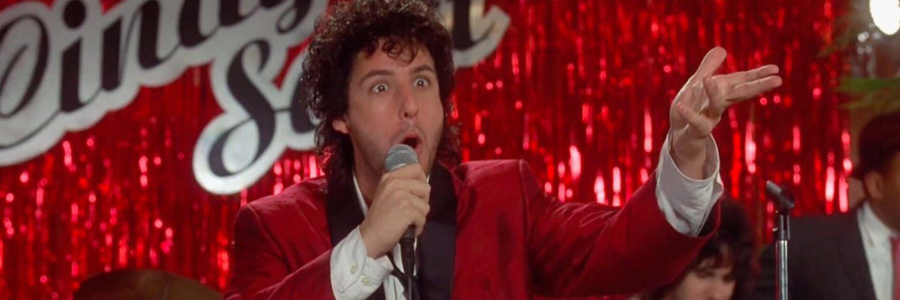 Man in red and white suit holding a microphone