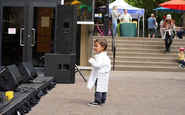 A little kid in front of the stage outside of the Hult center