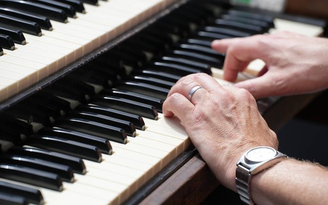 An individual's hands on a piano