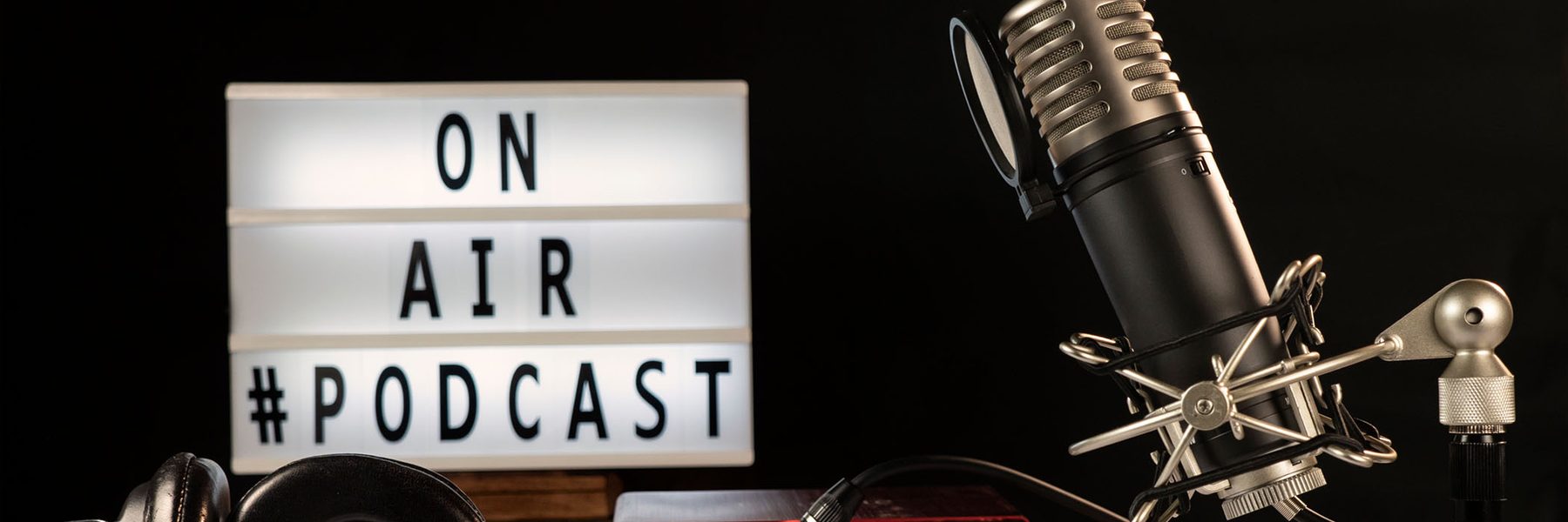 Signage says ON AIR #PODCAST with microphone pictured