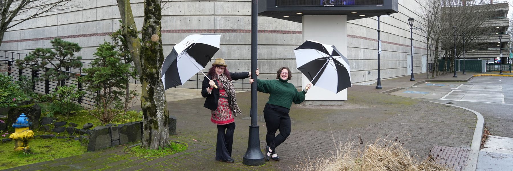 Two women under an umbrella with logo 